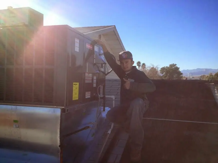 HVAC technician performing Air Duct Repair on a rooftop unit in Sidney